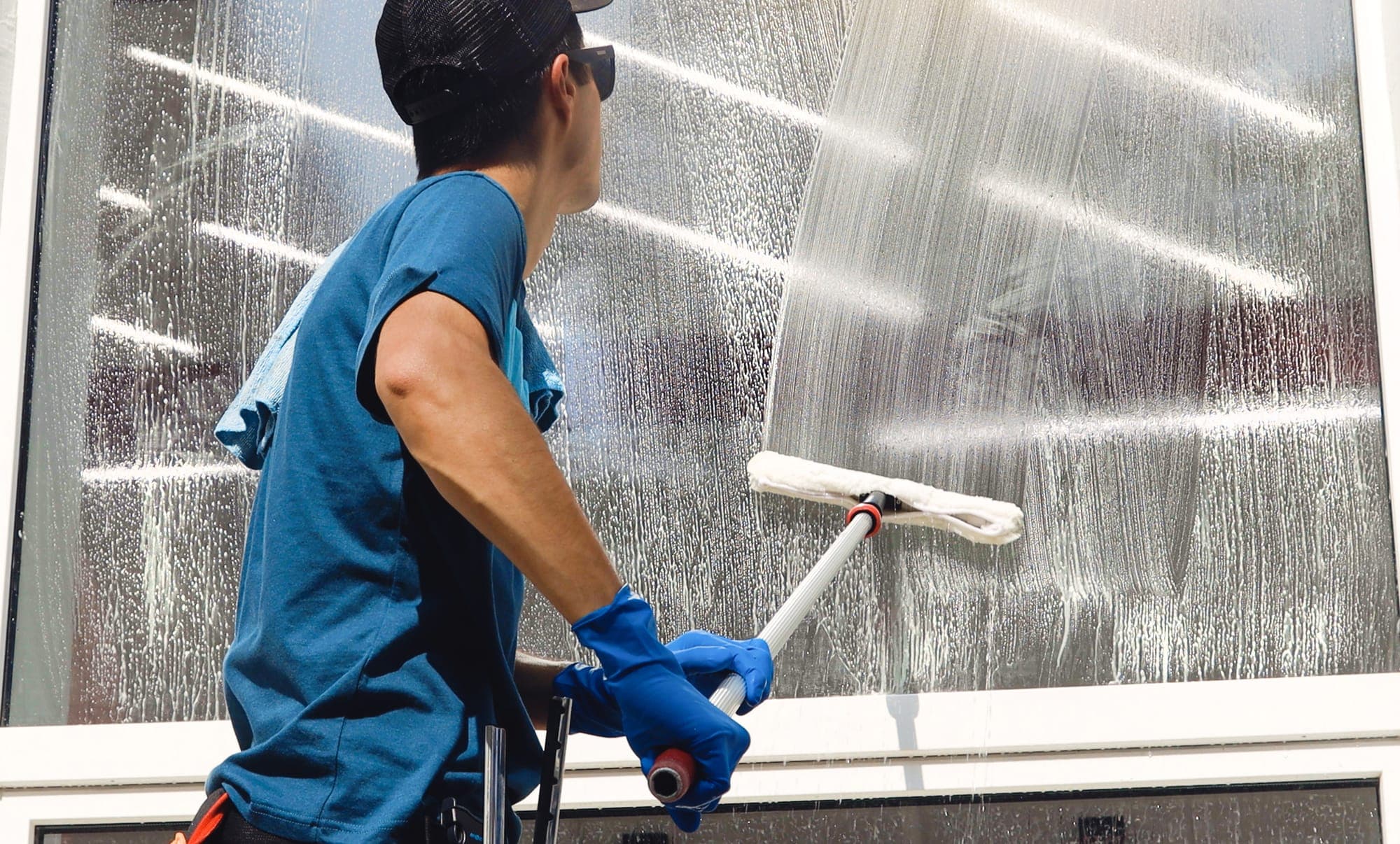 A professional window cleaner squeegeeing glass at a Spokane Valley property